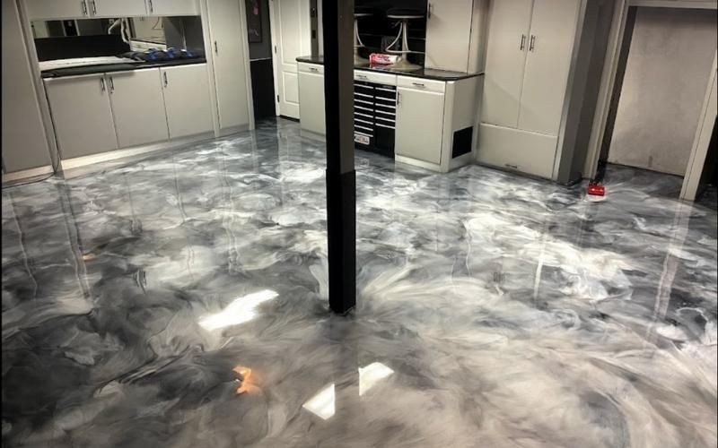 Room with a glossy, marbled epoxy floor and modern white cabinets.